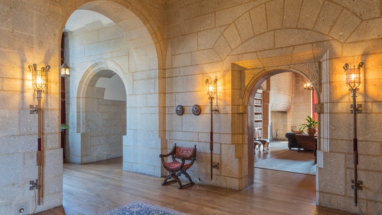 Interior of stone building with old fashioned lights that look like medieval torches attached to wall